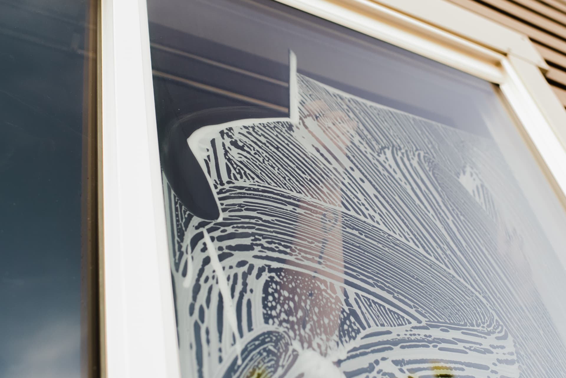 Slip solution being squeegeed across a residential window during film installation