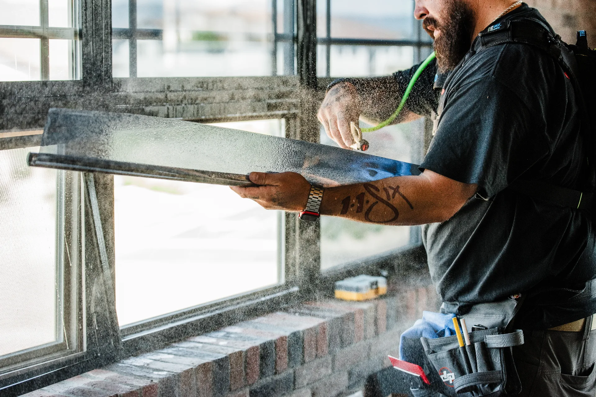 Installer spraying slip solution onto a pane of commercial window film