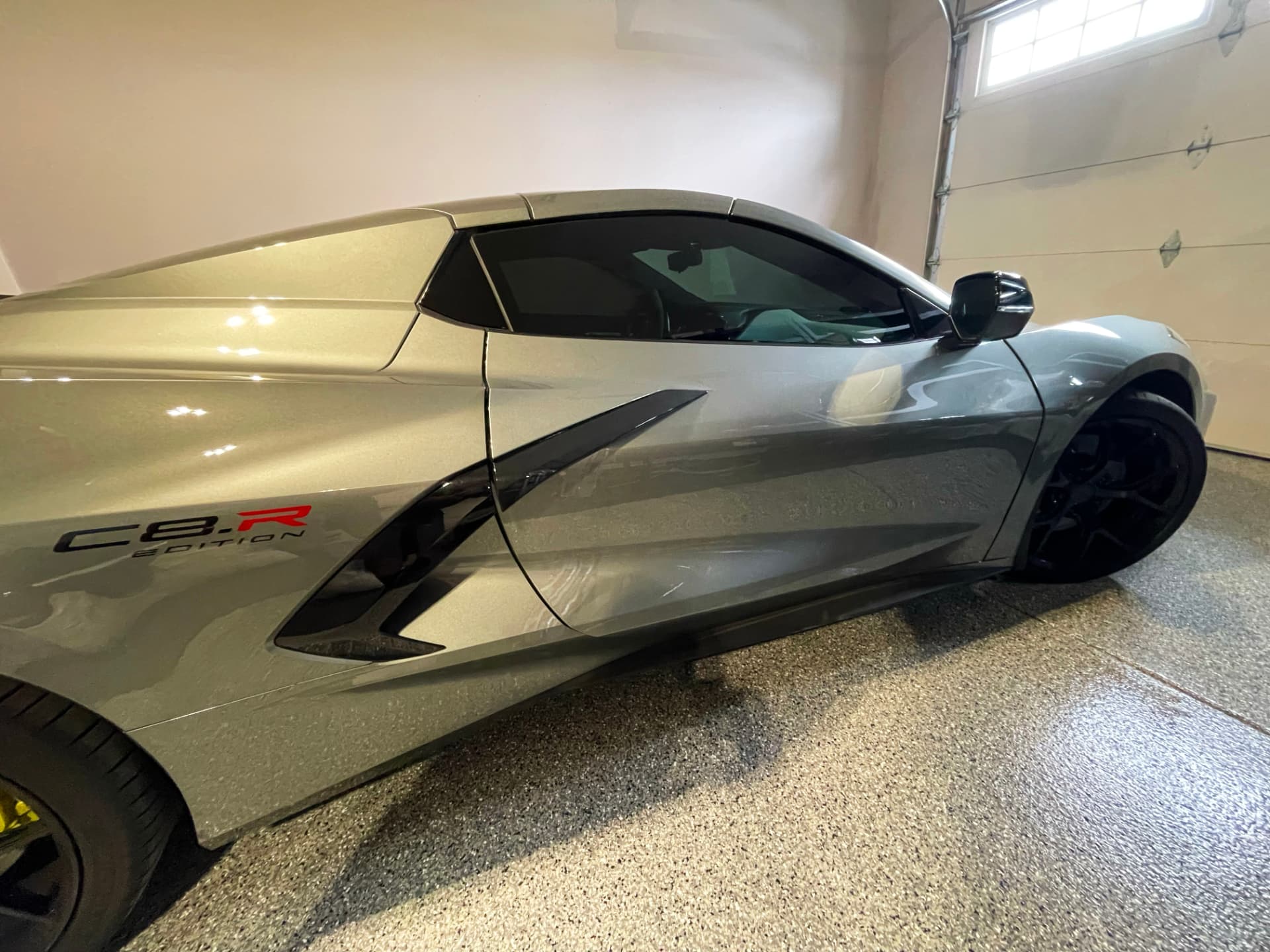 Silver Corvette with tinted windows in a garage